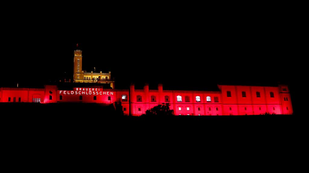 rot illuminierte Brauereigebäude der Feldschlösschenbrauerei in Rheinfelden