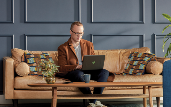 Man arbeitet im Home Office auf der Couch mit dem Laptop