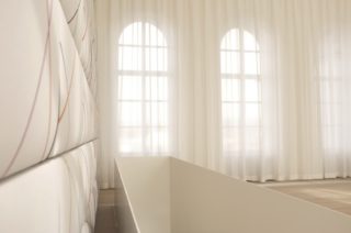 Im Musiksaal der Musikinsel Rheinau kommen Absorber Light-Vorhänge der Firma Annette Douglas Acoustics zum Einsatz. Die motorisierten, halbtransparenten Akustikvorhänge dienen gleichzeitig als Blendschutz.