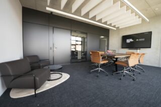 Meetingraum mit Tisch, Stühlen, Couch und Medientechnik