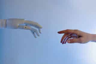 Roboterhand und menschliche Hand, die sich fast berühren