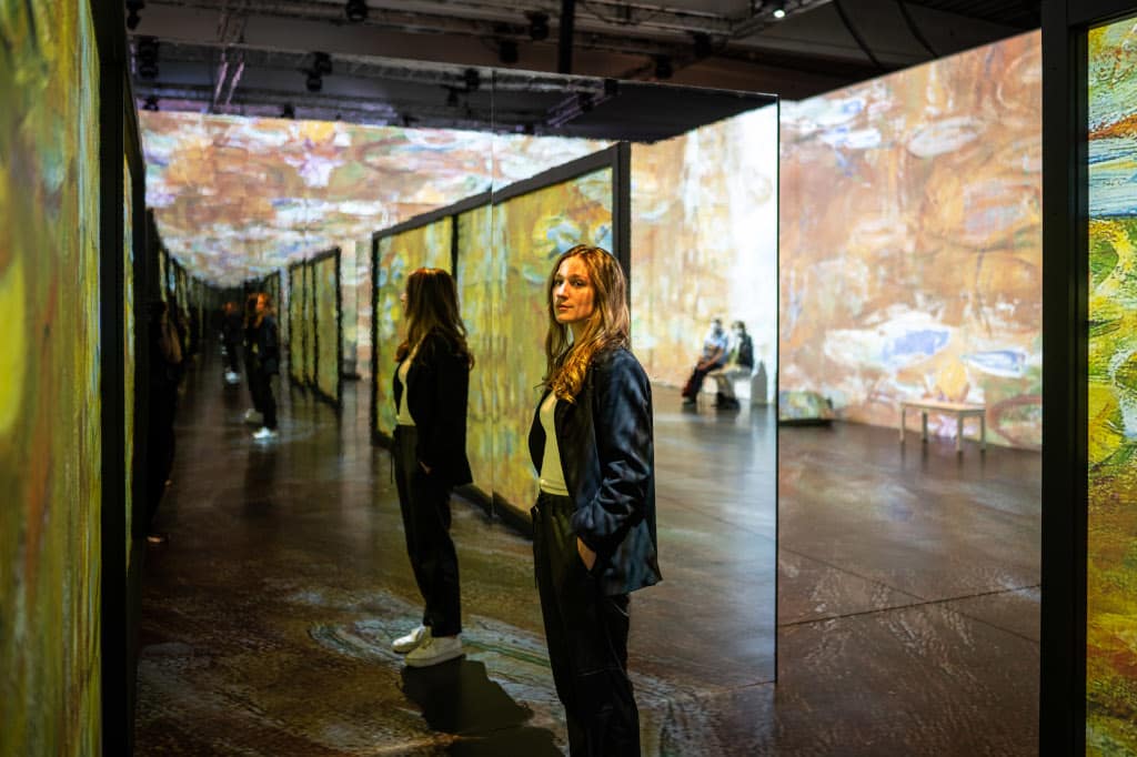 Person in Monets Garten in der immersiven Ausstellung in Stuttgart