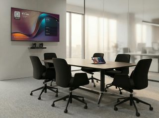 Besprechungszimmer mit Tisch ohne Personen. An der Wand ein Bildschirm und die 1 Beyond i12D Kamera