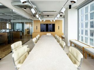 Besprechungsraum mit langem weißen Tisch und weißen Stühlen