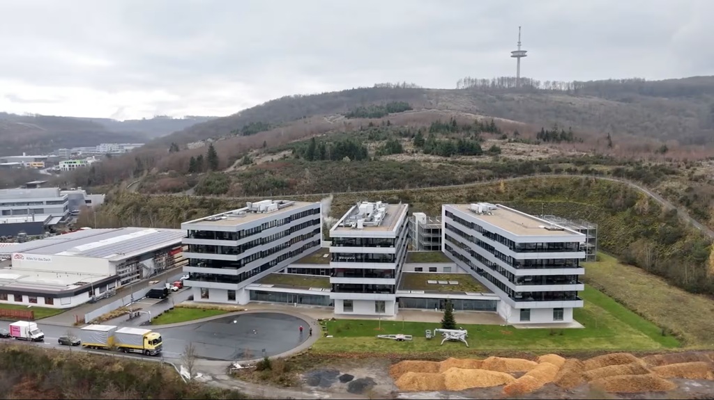 Außenansicht eines modernen Bürogebäudes von ifm mit mehreren Gebäudetrakten und großen Fensterflächen.